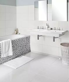 a white bathroom with two sinks and a bathtub