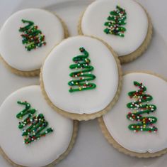 decorated cookies on a white plate with green and red decorations