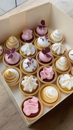 a box filled with cupcakes sitting on top of a wooden table