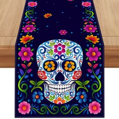 a table runner with a colorful skull and flowers on the front, along with a wooden floor