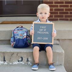 a little boy sitting on the steps holding a sign that says first day of preschool