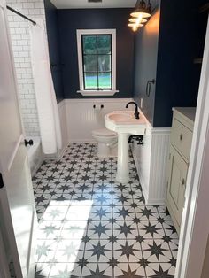 a bathroom with black and white tile flooring next to a sink, toilet and bathtub