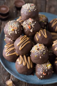 chocolate covered candies with peanut butter and sprinkles on a blue plate