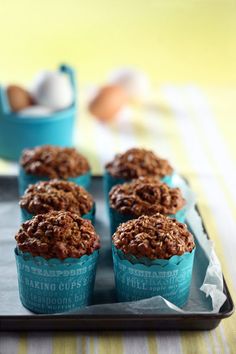 several muffins on a tray with eggs in the background