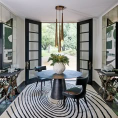 the dining room is decorated in black and white with an abstract rug on the floor