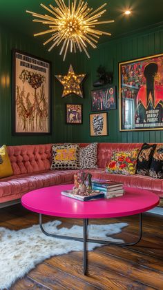 a living room with green walls, pink couch and coffee table in front of two pictures on the wall