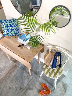 a table with a mirror, bag and flip flops on it next to a chair