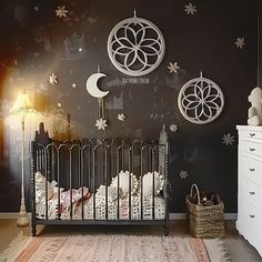 a baby's room decorated in black and white with stars, crescents, and moon phases on the wall