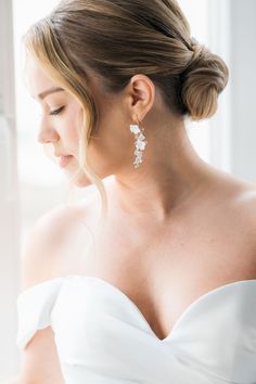 a woman in a white dress wearing earrings