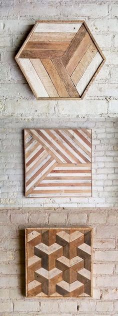 three pieces of wood sitting on top of a white brick wall next to each other