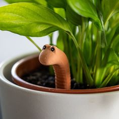 a plant with a toy snake sticking out of it's head in a pot