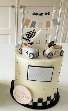 a birthday cake decorated with cars and bunting