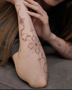 a woman with tattoos on her arm laying down