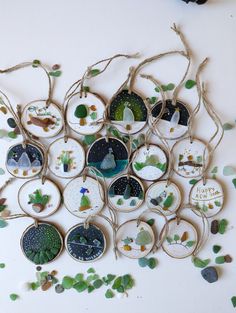 a bunch of ornaments that are hanging on a tree branch with some leaves around them