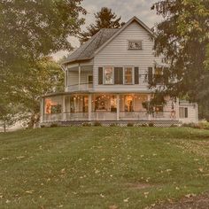 a large white house sitting on top of a lush green field