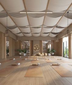 an empty room with yoga mats and potted plants on the floor in front of large windows