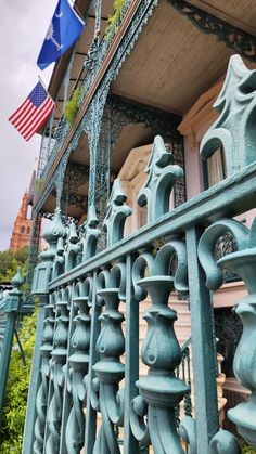 an american flag is hanging on the side of a building with iron railings and balconies