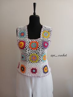 a crocheted top on a mannequin with white pants and black headband