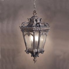 an old fashioned light hanging from a ceiling in a room with gray walls and flooring