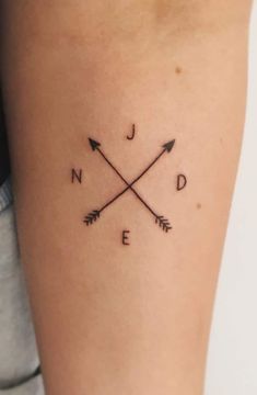 a woman's arm with an arrow tattoo on it