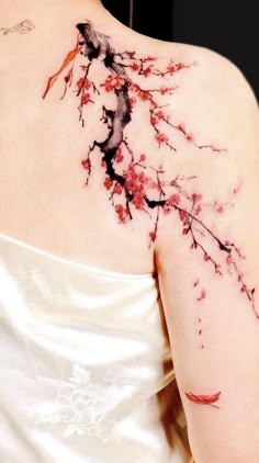 the back of a woman's shoulder with red flowers and leaves painted on it