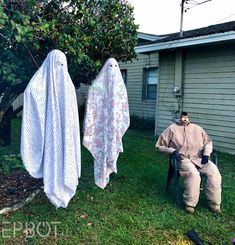 a man sitting in a lawn chair next to two towels hanging on a clothes line