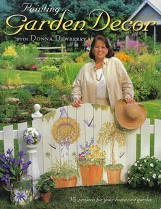 a woman standing on top of a white fence next to flowers and potted plants