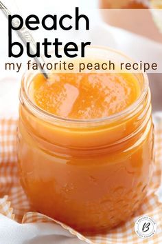 a jar filled with peach butter sitting on top of a checkered cloth next to a spoon