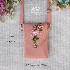 a pink purse with flowers on it and measurements for the contents to be taken out