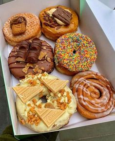 a box filled with lots of different flavored donuts