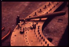 a close up of an old fashioned musical instrument on a wooden table with tools attached to it