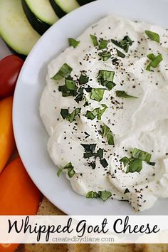 a white plate topped with whipped goat cheese surrounded by sliced cucumbers and carrots