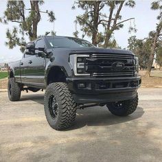 a large black truck parked on top of a parking lot