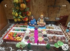 there are many different foods on the table with buddha statues in front of them and fruit