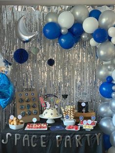 a space themed party with balloons and desserts