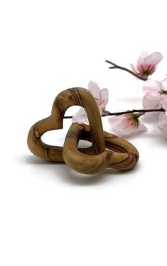 two wooden rings sitting on top of each other next to pink flower stems and branches