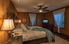 a bed room with a neatly made bed and two lamps on either side of the bed