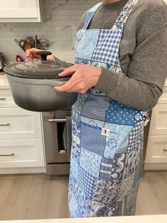 a woman in an apron is holding a pan