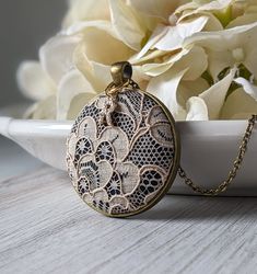 "The classic look of this lace pendant with initial charm makes it the perfect, personalized gift for her - this necklace is handmade with vintage beige lace that is actually antique in age since it's from the 1920s. It is made of cotton, as well as the black background fabric that is behind the lace. The gold color and clear crystal capital letter initial charm makes this a unique way to personalize the necklace as an anniversary gift for your wife or loved one's 13th year anniversary, which is the material lace, or the 2nd year anniversary, which is the material cotton. The pendant measures about 1.5 inches wide and the backing is a dark bronze color made of metal alloy. See the photos for popular chain length examples, or leave me a note at checkout for any custom length. Each piece of Elegant Vintage Collection Necklaces With Round Pendant, Elegant Vintage Necklace With Round Pendant, Elegant Vintage Round Pendant Necklace, Handmade Lace Jewelry For Gifts, Elegant Lace Jewelry For Gifts, Elegant Vintage Charm Necklace For Keepsakes, Vintage Lace Jewelry For Gifts, Vintage Lace Jewelry For Weddings, Elegant Lace Trim Jewelry For Gift