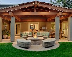 an outdoor living area with couches, tables and fire pit in the middle of it