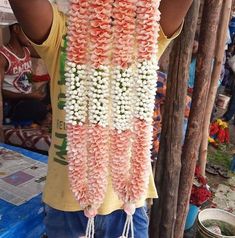 a man is holding up some flowers in front of his face and hands to the camera