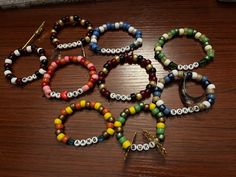 several bracelets with beads and charms on a table