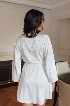 Shout it from the rooftops - She's tying the knot! Unleash sophistication in our Aimee Pearl Beaded Bride Robe. Featuring hand beaded pearl 'Bride' at the back and combining a timeless silhouette with chic angel sleeves and a graceful petal hem, the Aimee brings together traditional and modern fashion in a flawless union. Made from our LR exclusive satin, it has just enough stretch to create the perfect drape for the angel wing sleeves and floating petal hem. Delicate gather details adorn the sh Pearl Bride, Bridal Party Robes, Angel Sleeves, Bridal Robe, Tying The Knot, Cami Set, Angel Sleeve, Bridesmaid Robes, Wedding Lingerie