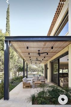 an outdoor covered patio with furniture and trees