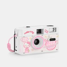 a white and pink camera with hello kitty pictures on the front, sitting on a white surface