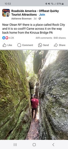 a person walking down a narrow path in the middle of some mossy rock formations