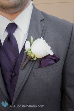 a man wearing a suit and tie with a boutonniere on his lapel