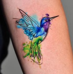 a watercolor hummingbird tattoo on the arm