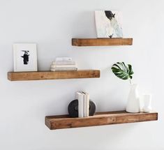 two wooden shelves with books and vases on them