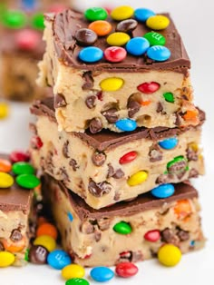 three pieces of candy bars stacked on top of each other with m & m candies all over them